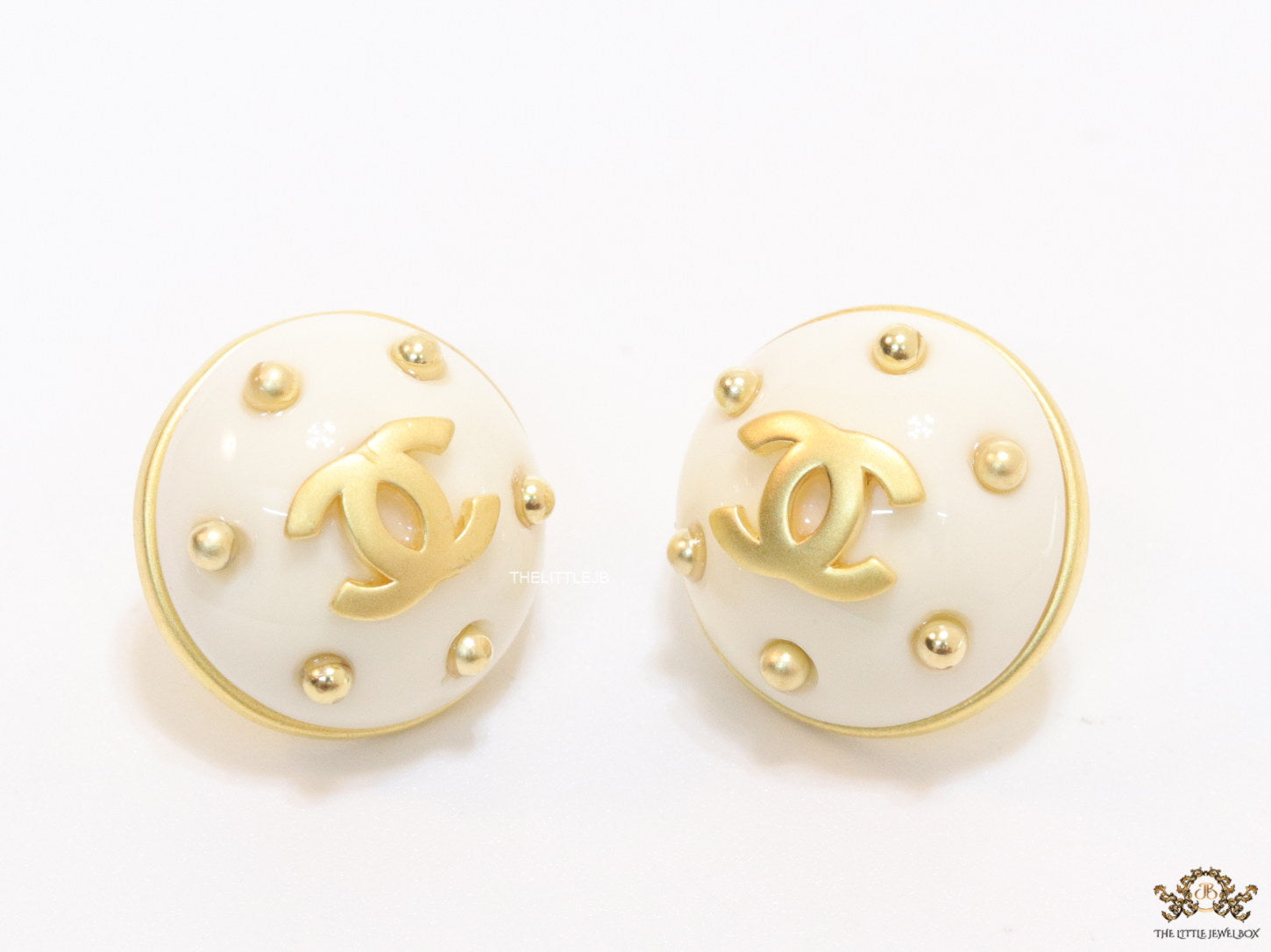 White and golden round studs with twin C motif