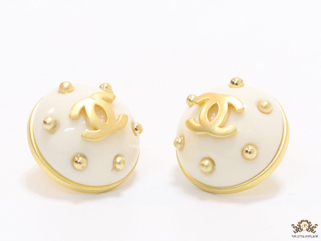 White and golden round studs with twin C motif