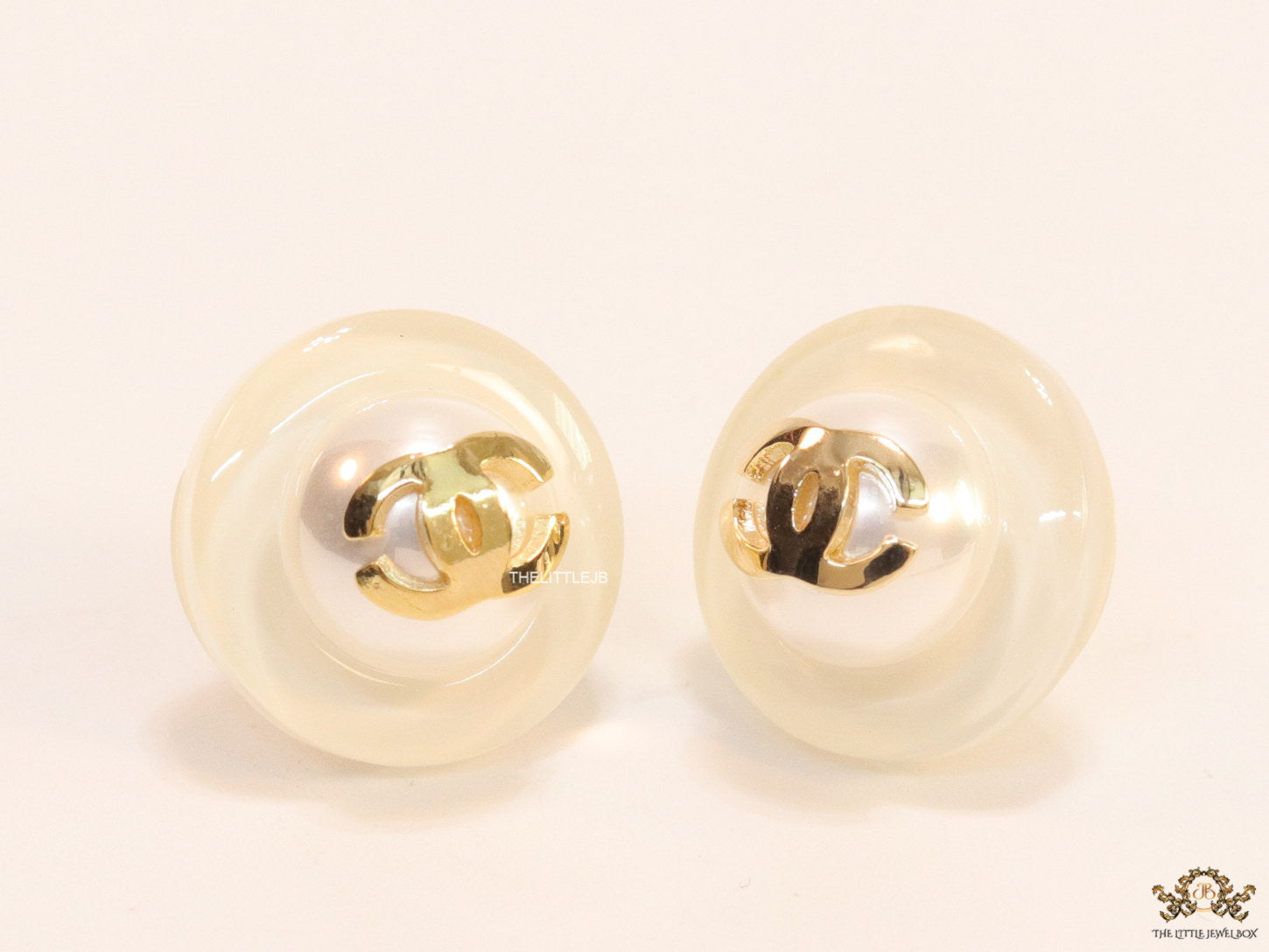 White acrylic studs with pearl and twin C motif