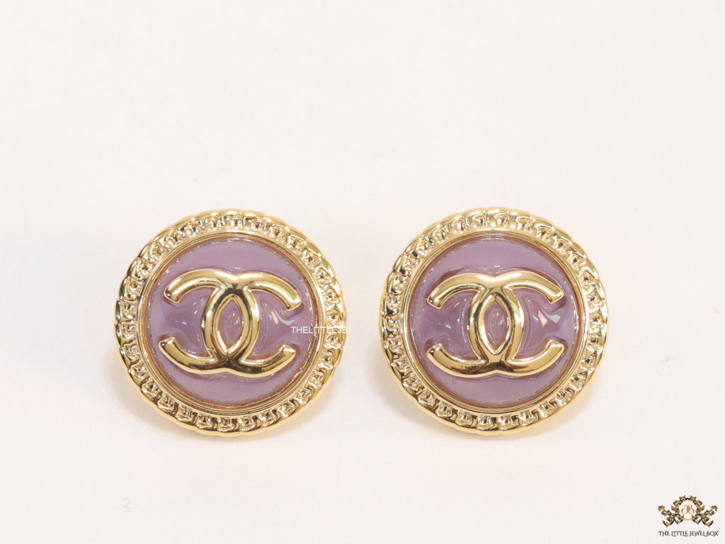Twin C motif gold plated round studs on lilac acrylic base