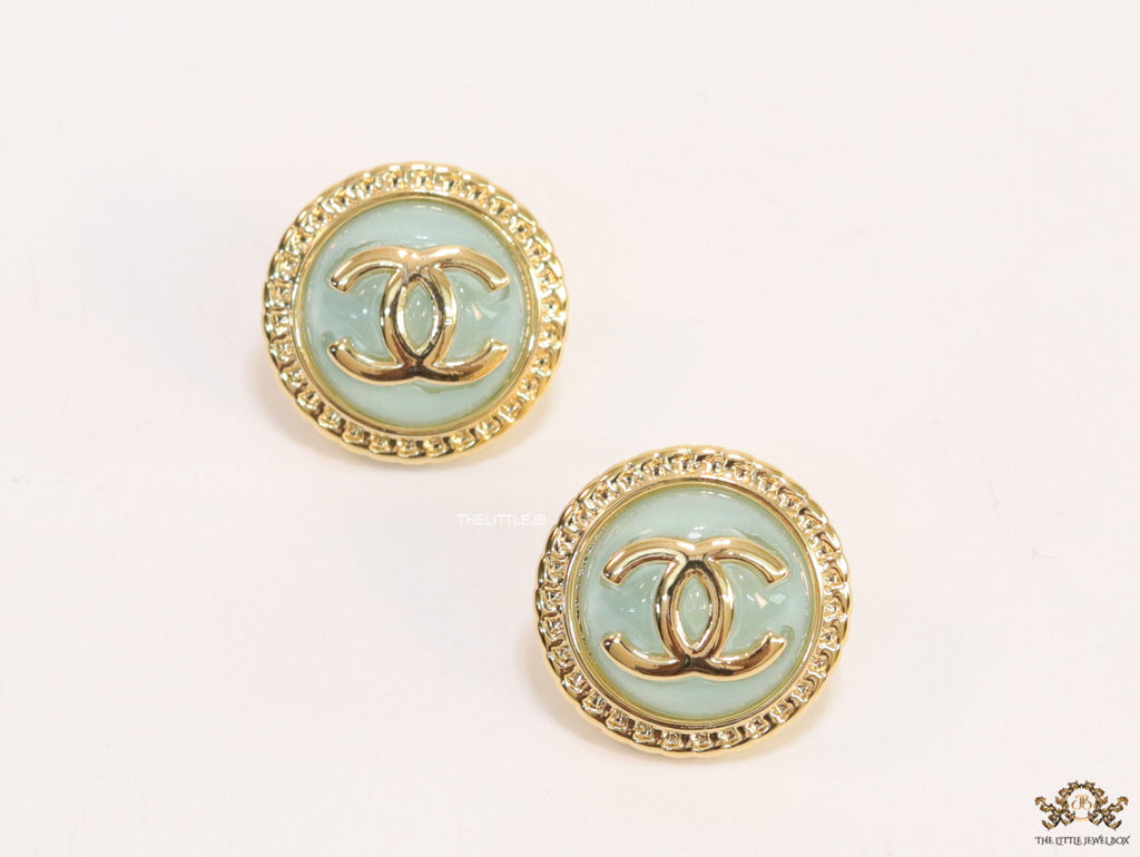 Twin C motif gold plated round studs on mint green acrylic base