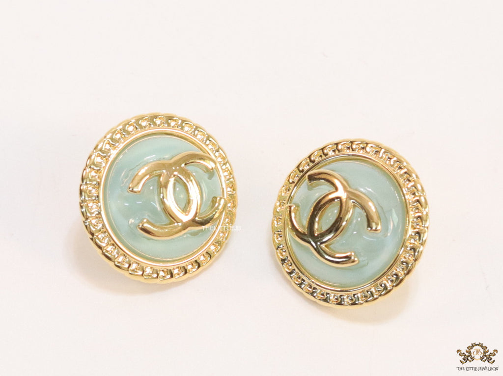 Twin C motif gold plated round studs on mint green acrylic base