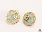 Twin C motif gold plated round studs on mint green acrylic base