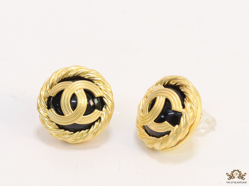 Twin C motif matt gold plated round studs on black base