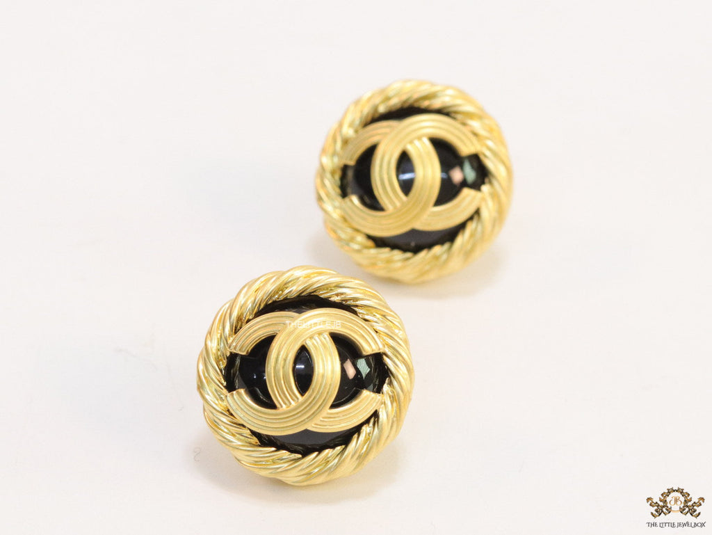 Twin C motif matt gold plated round studs on black base