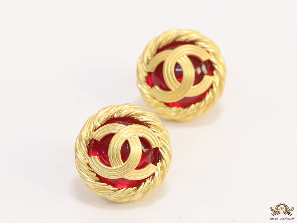 Twin C motif matt gold plated round studs on red base