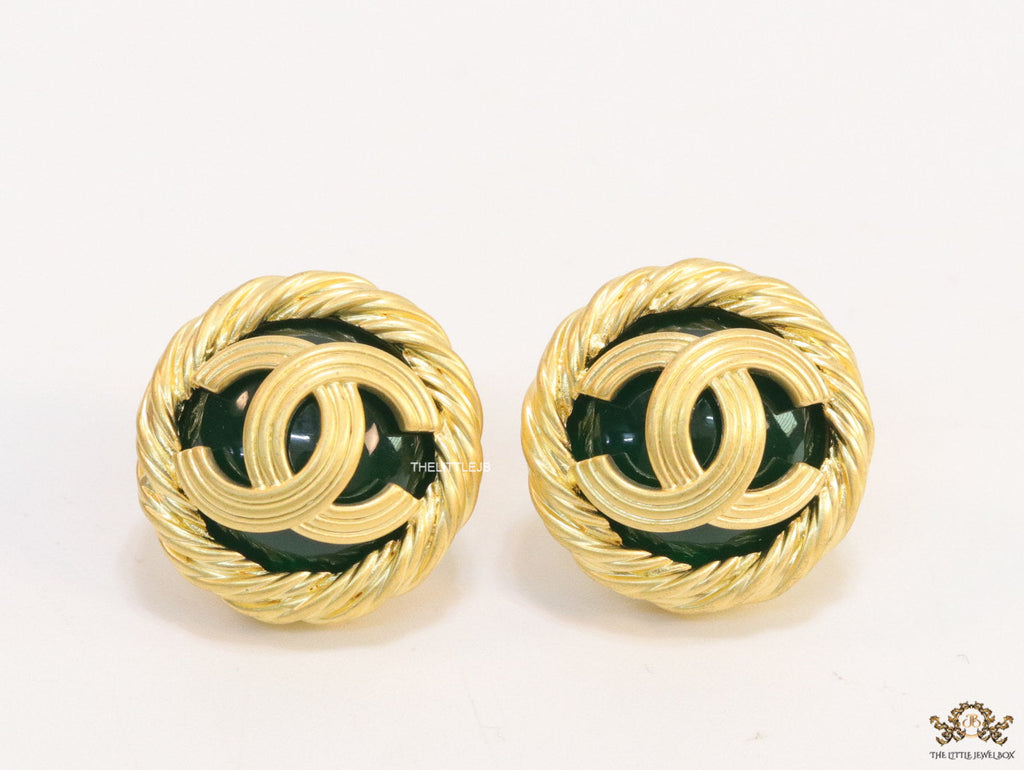 Twin C motif matt gold plated round studs on deep green base