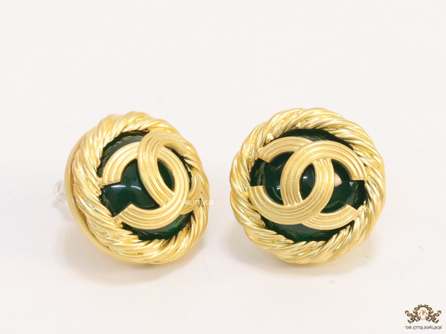 Twin C motif matt gold plated round studs on deep green base