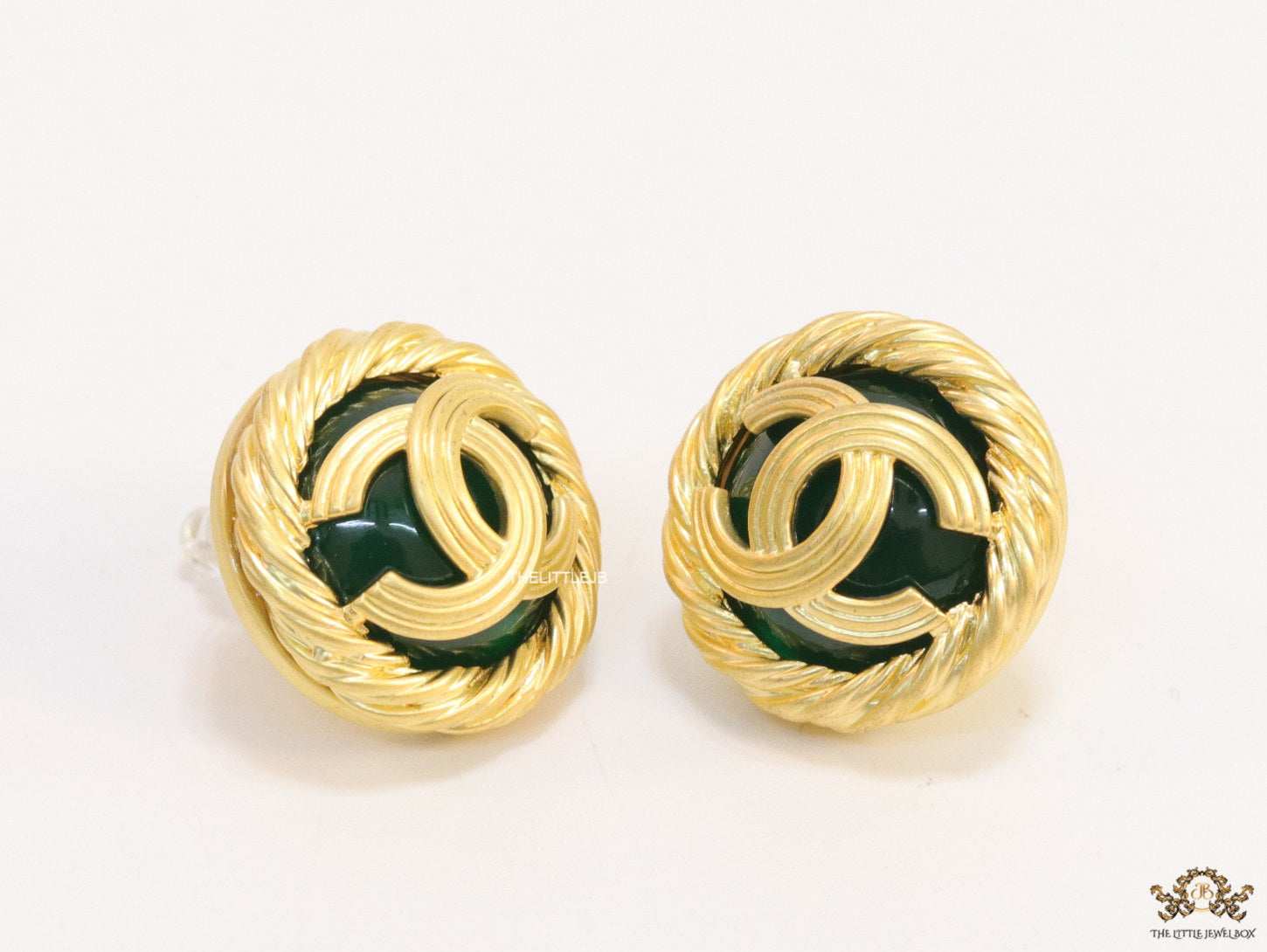 Twin C motif matt gold plated round studs on deep green base