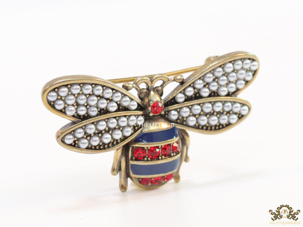Antique gold finish bee brooch with white and red stones and blue details