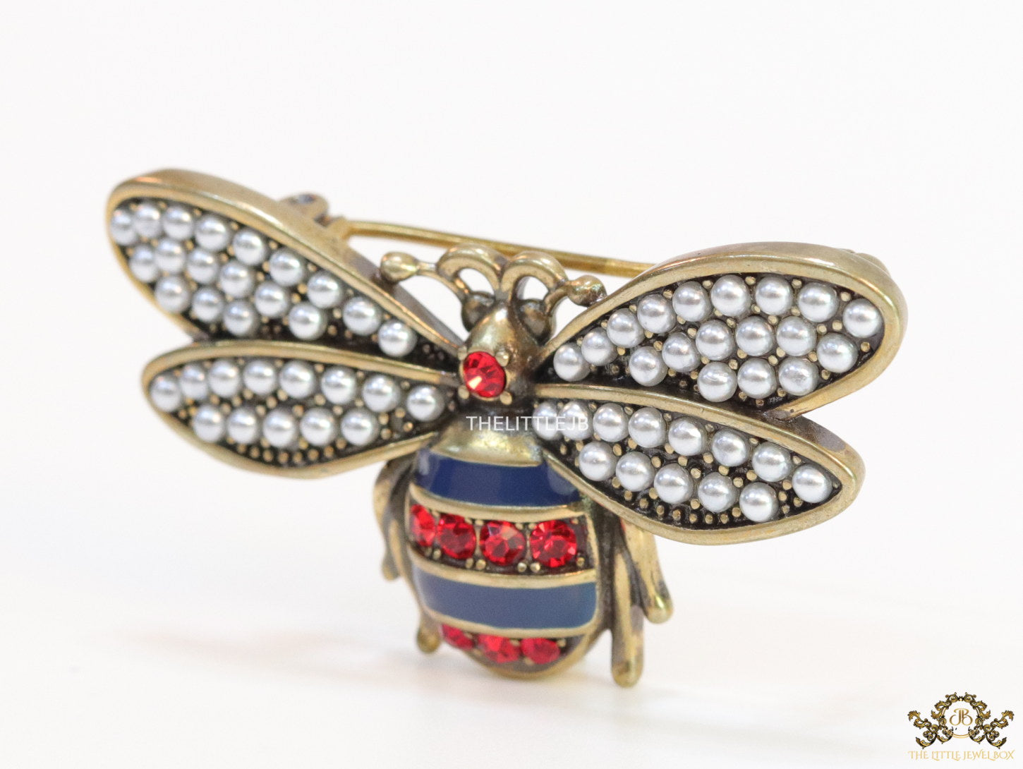Antique gold finish bee brooch with white and red stones and blue details