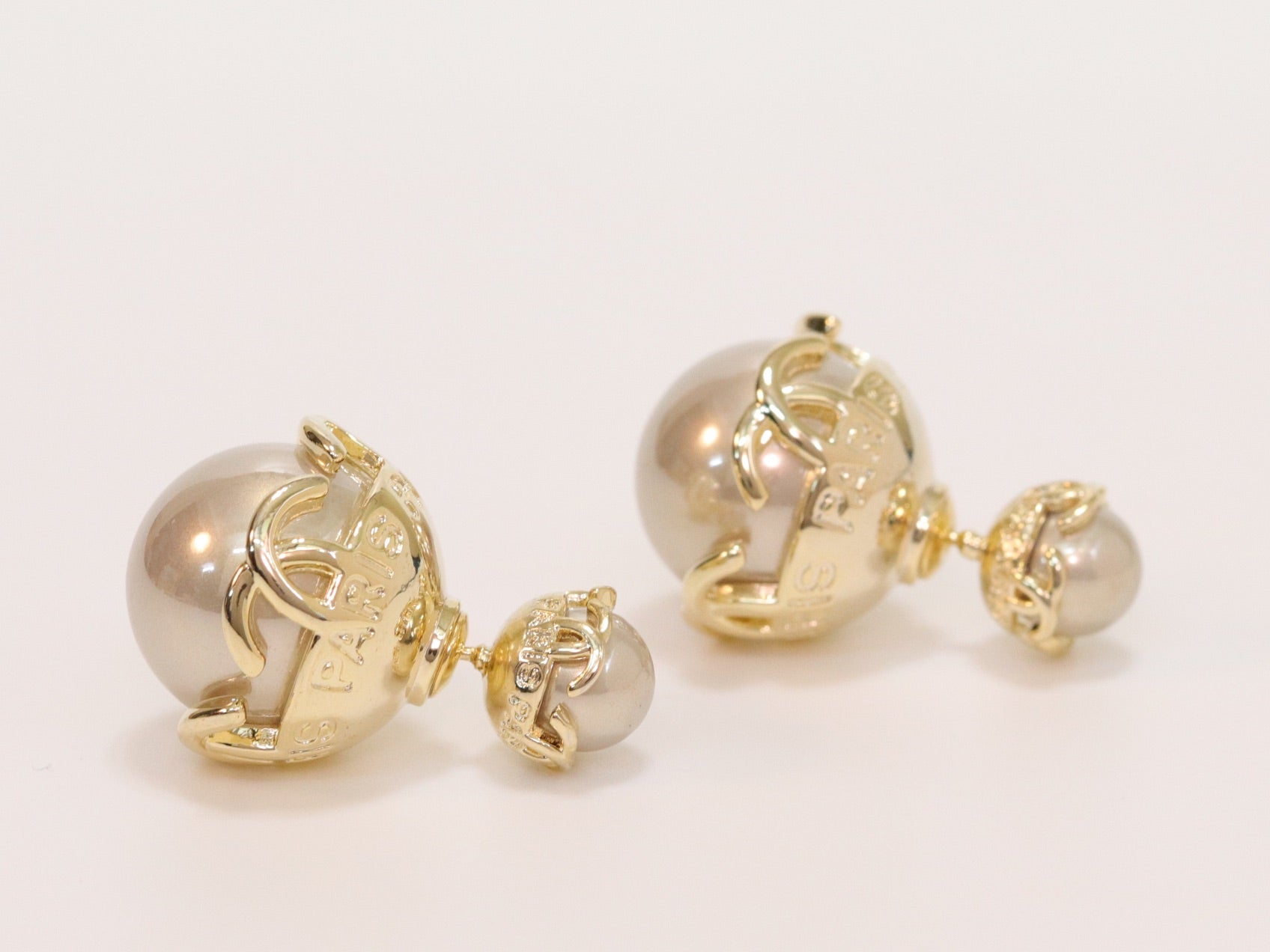 Double C beige pearl studs in gold finish