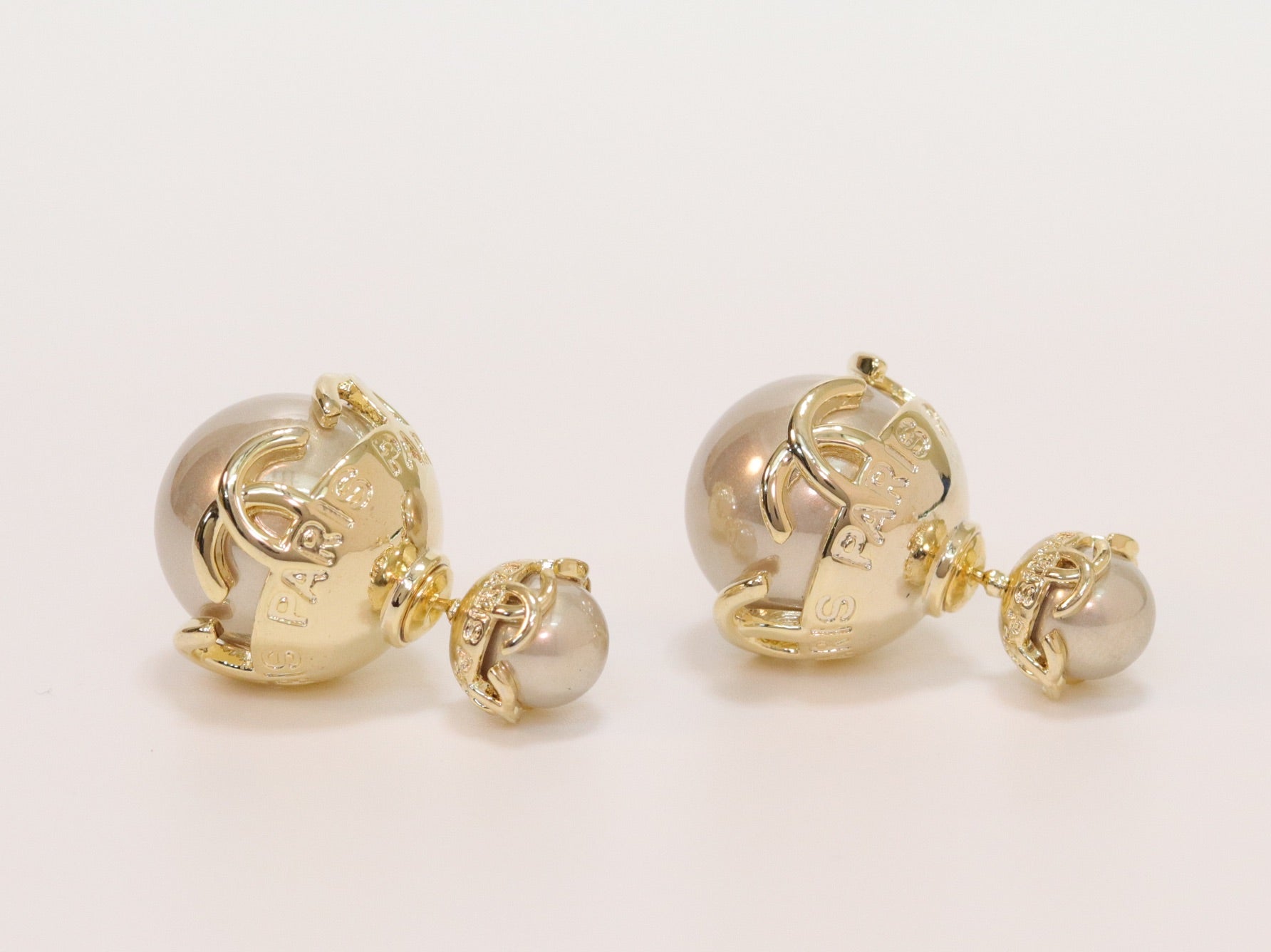 Double C beige pearl studs in gold finish