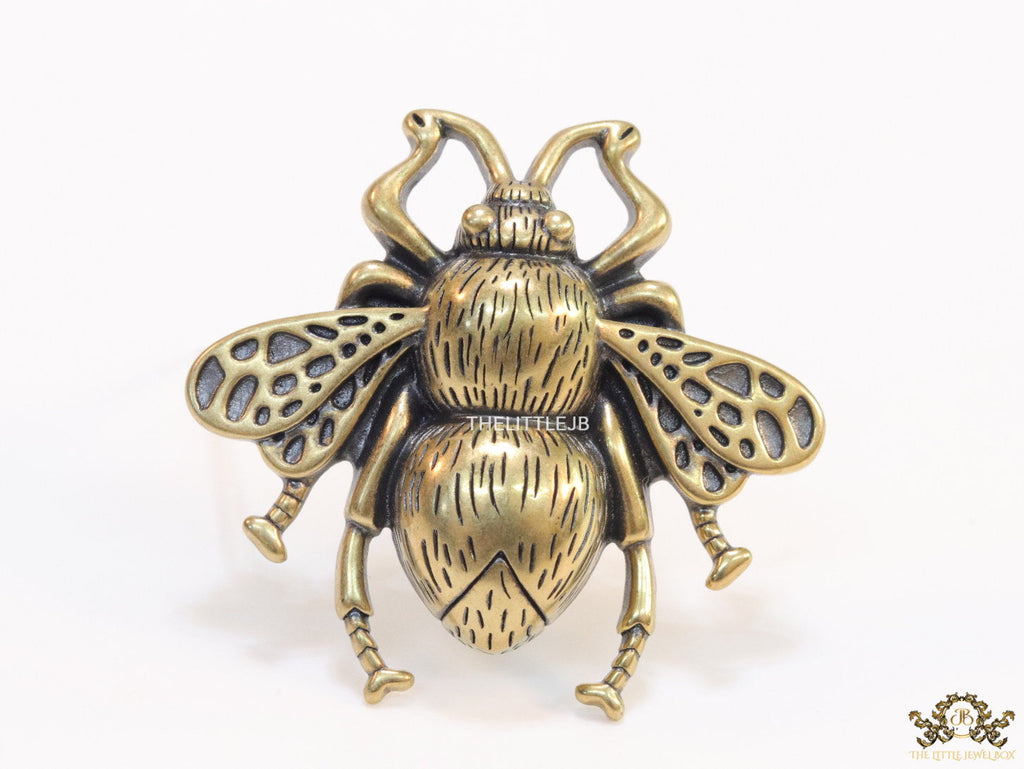Antique gold finish bee brooch with white and red stones and blue details
