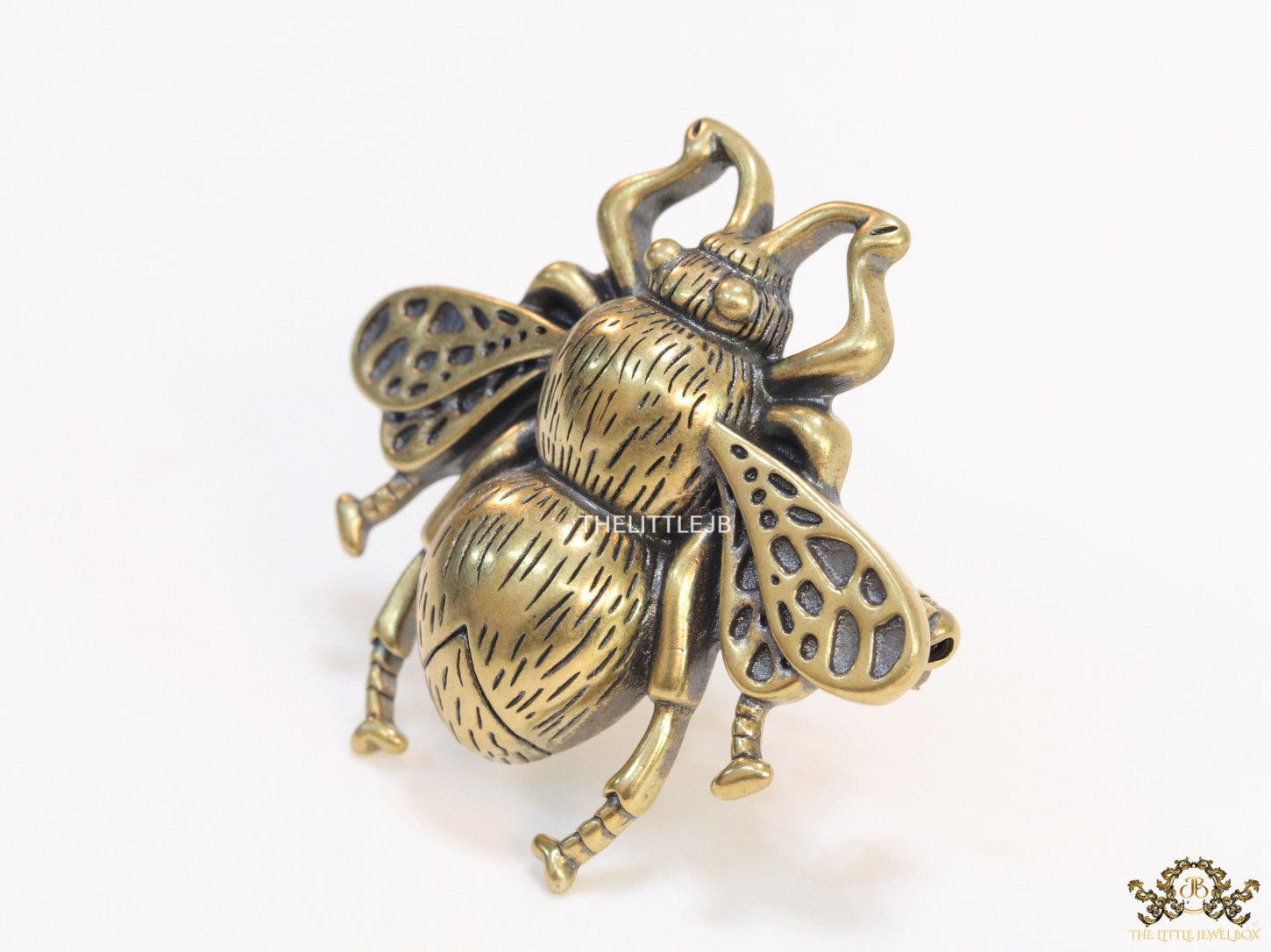 Antique gold finish bee brooch with white and red stones and blue details