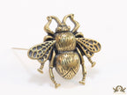 Antique gold finish bee brooch with white and red stones and blue details