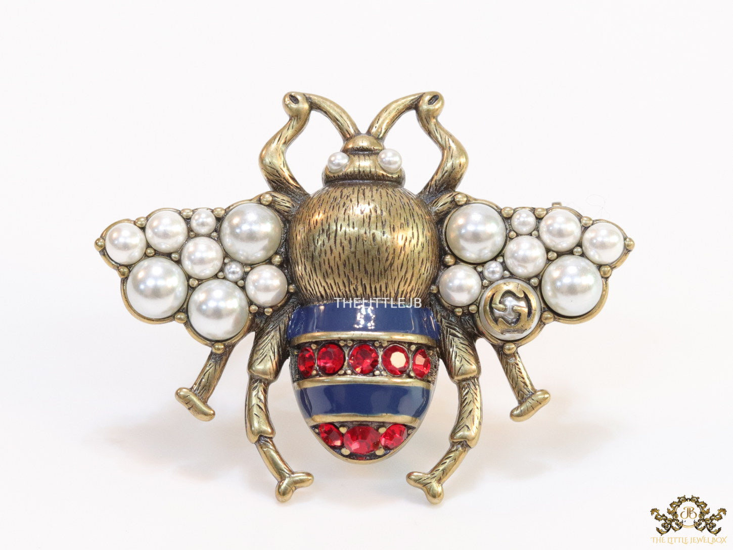 Antique gold finish double G bee brooch with blue details and white and red stones