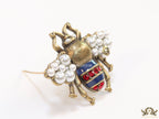 Antique gold finish double G bee brooch with blue details and white and red stones