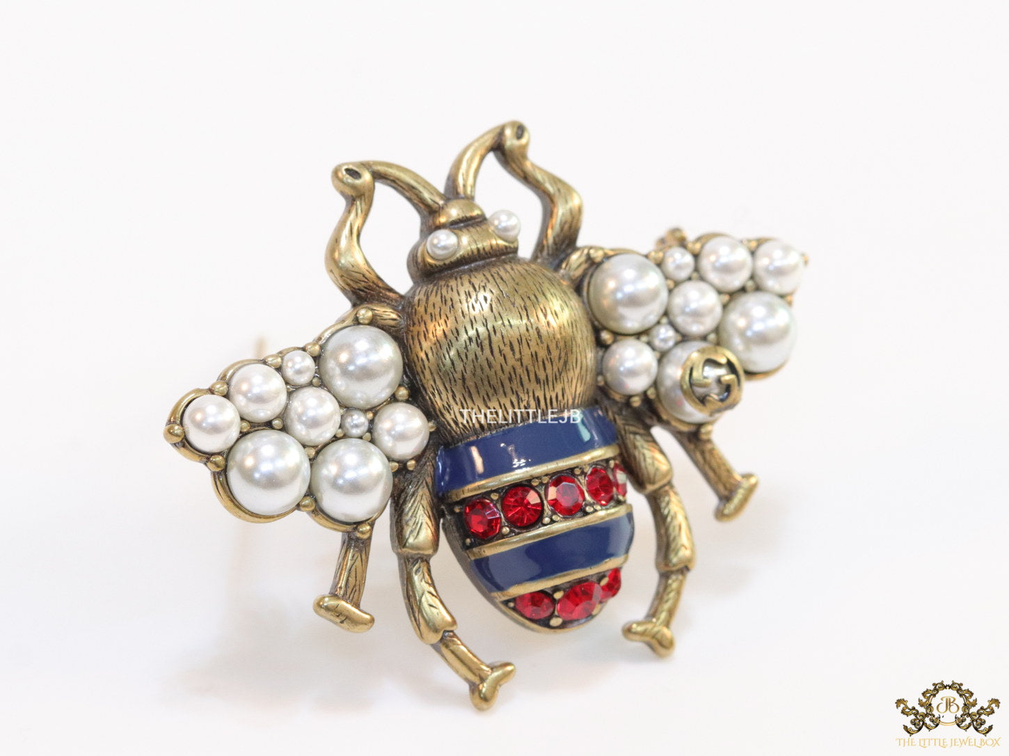 Antique gold finish double G bee brooch with blue details and white and red stones