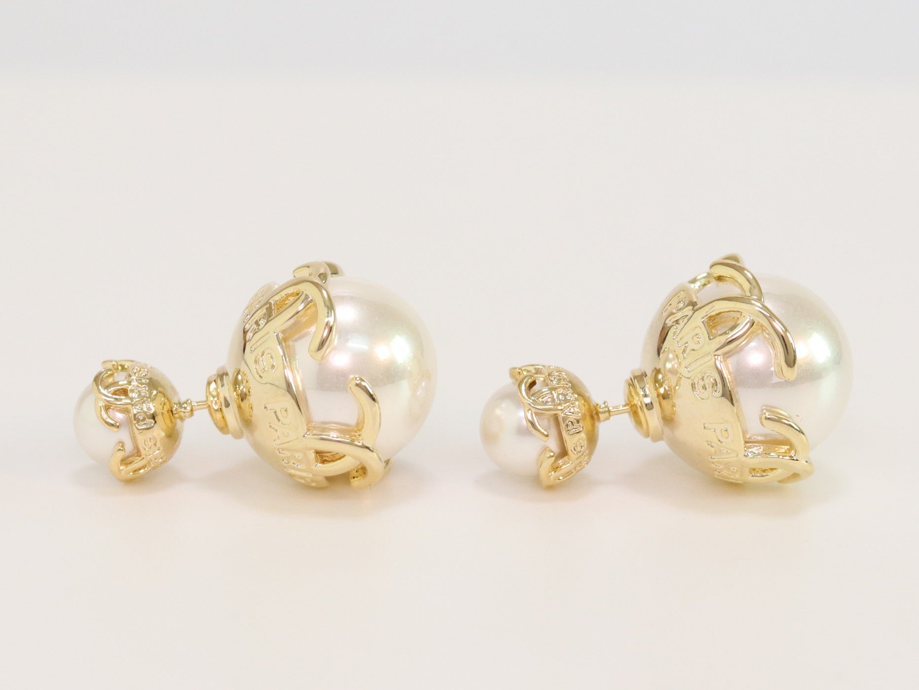 Double C white pearl studs in gold finish