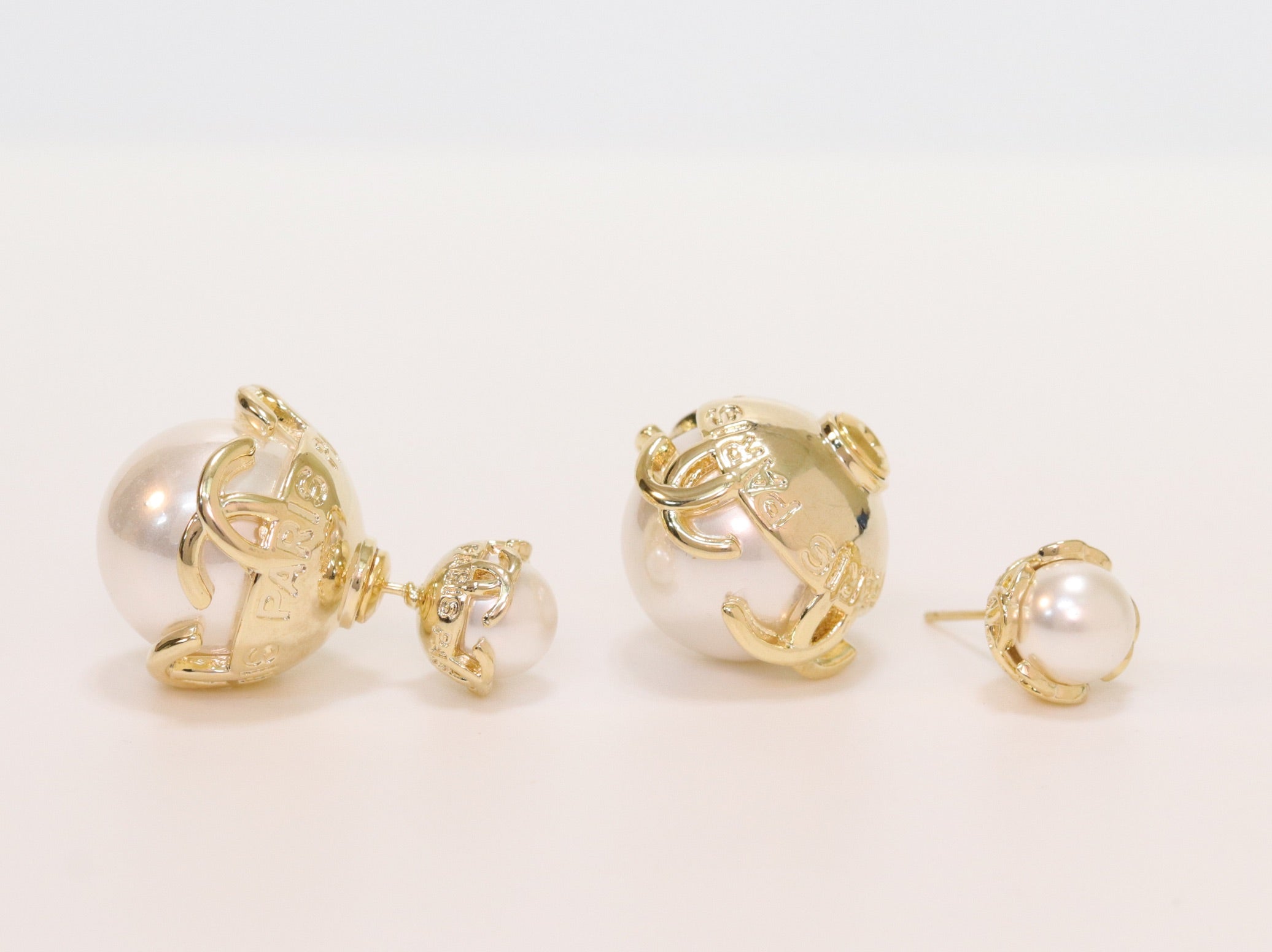 Double C white pearl studs in gold finish