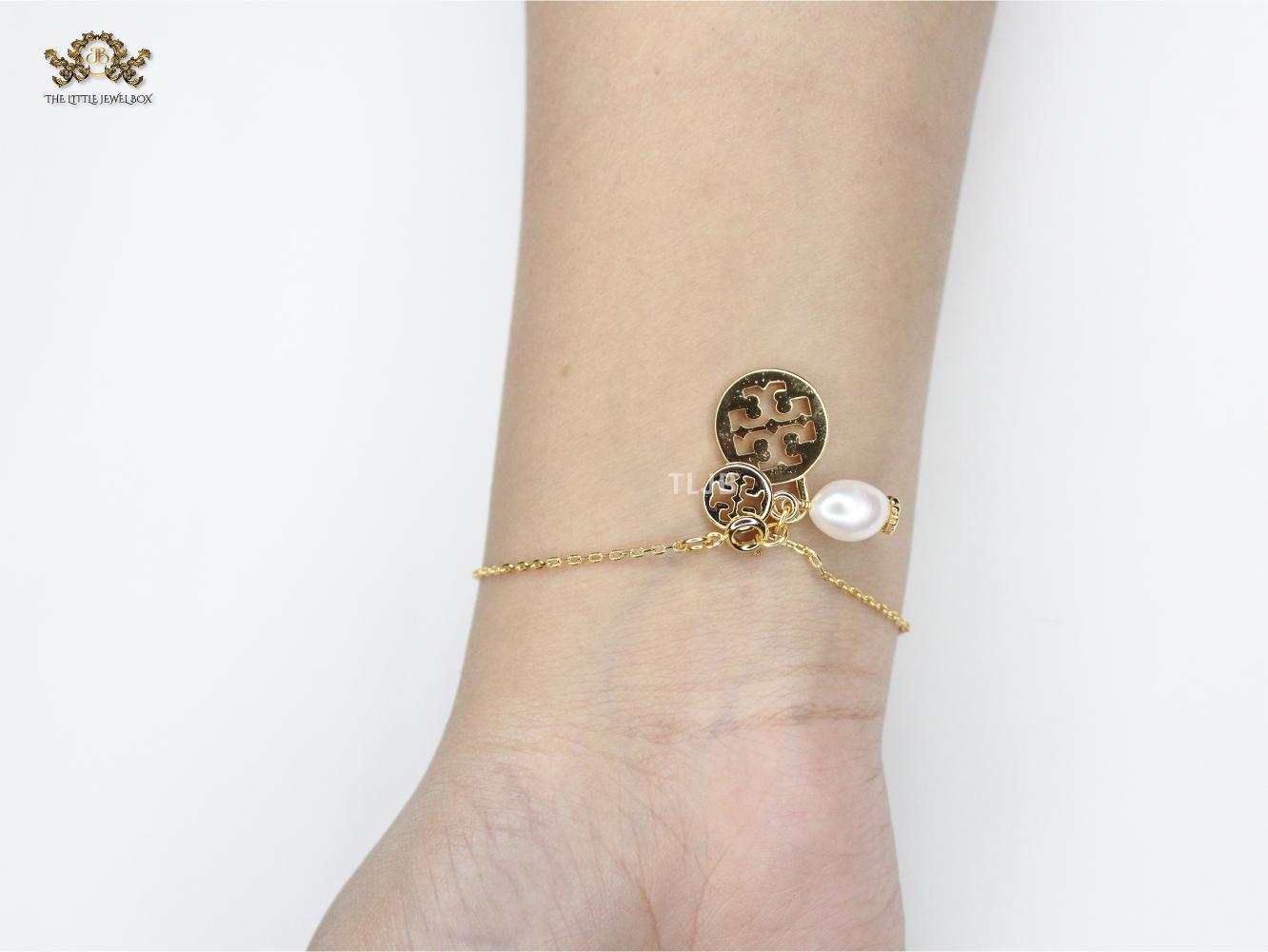 Three charm gold toned bracelet