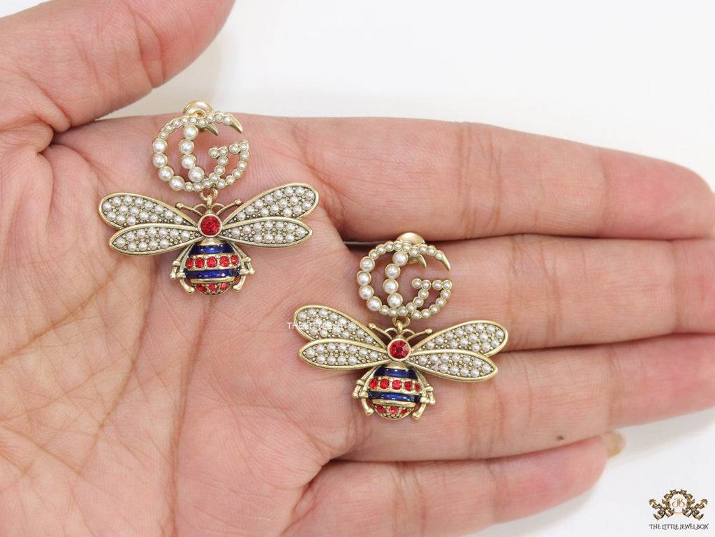 Pearl twin G earrings with pearl and multi cz bees in golden finish