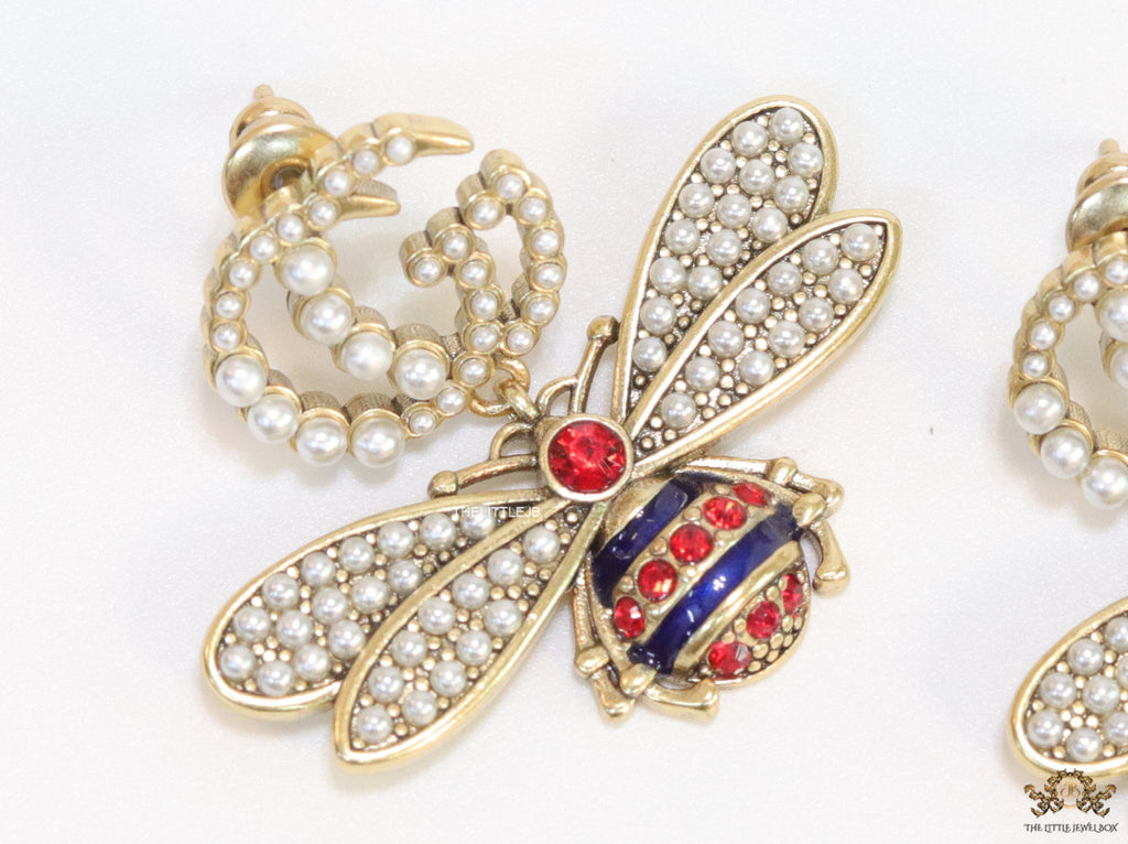 Pearl twin G earrings with pearl and multi cz bees in golden finish