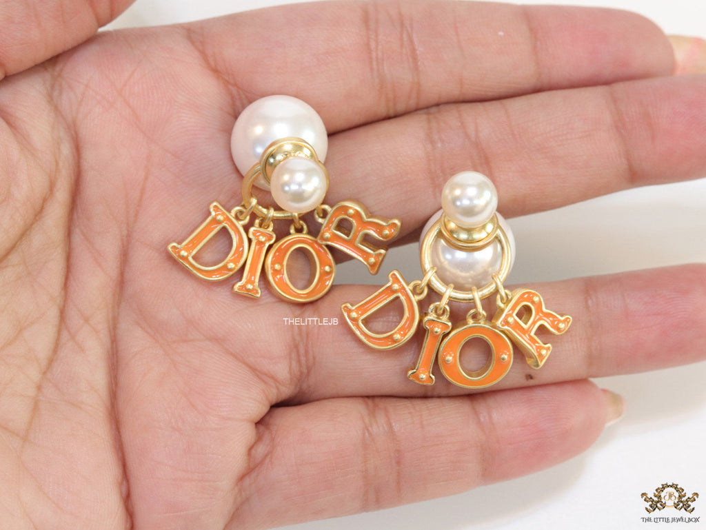 Pearl bomber earrings with golden and orange alphabet drop charms
