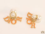 Pearl bomber earrings with golden and orange alphabet drop charms