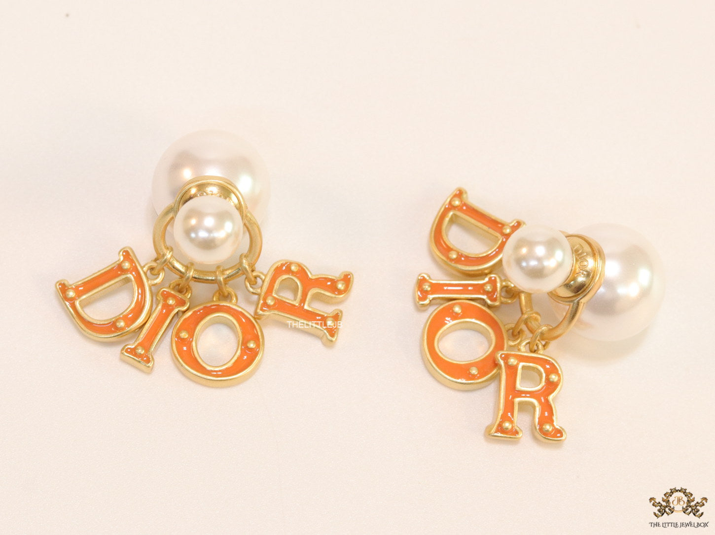 Pearl bomber earrings with golden and orange alphabet drop charms