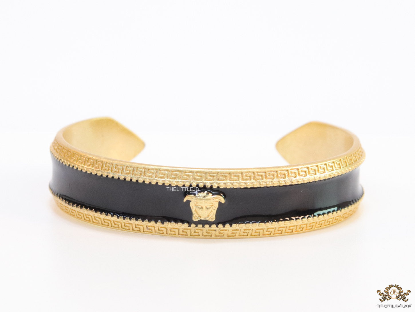 Band style black enamel bracelet with gold plated details and gold plated Medusa face motif