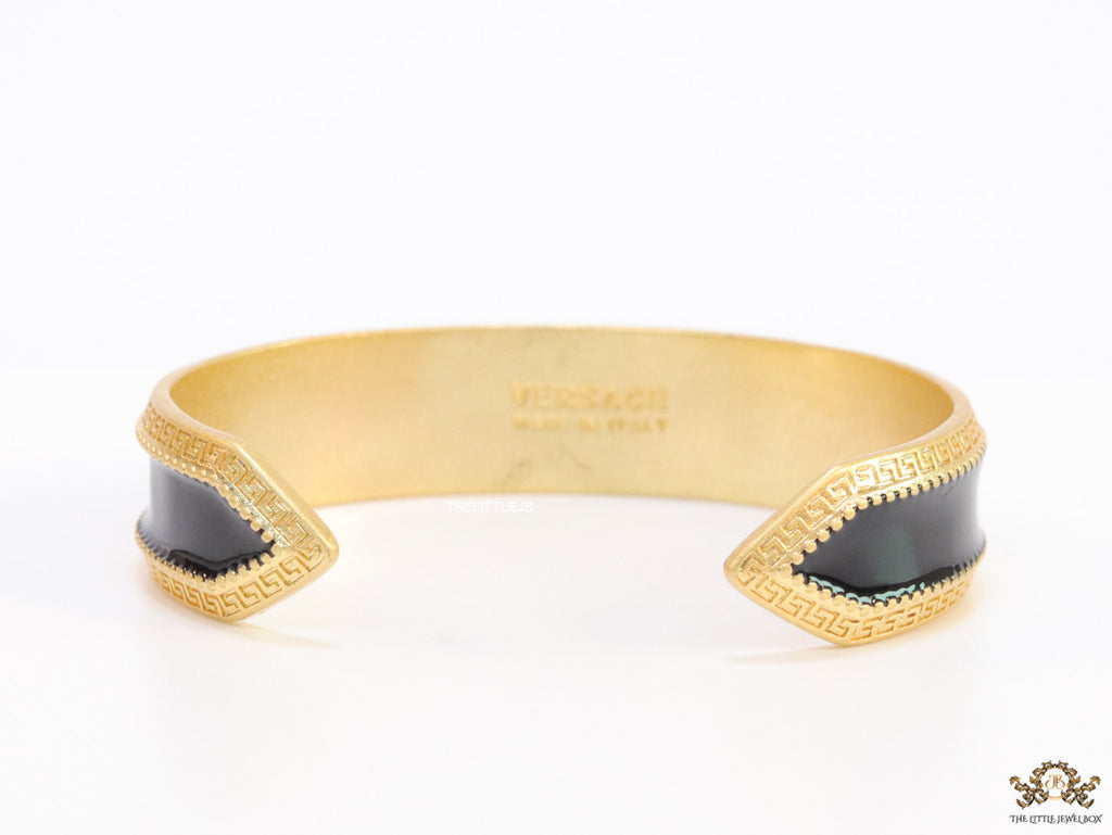 Band style black enamel bracelet with gold plated details and gold plated Medusa face motif
