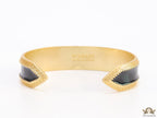 Band style black enamel bracelet with gold plated details and gold plated Medusa face motif