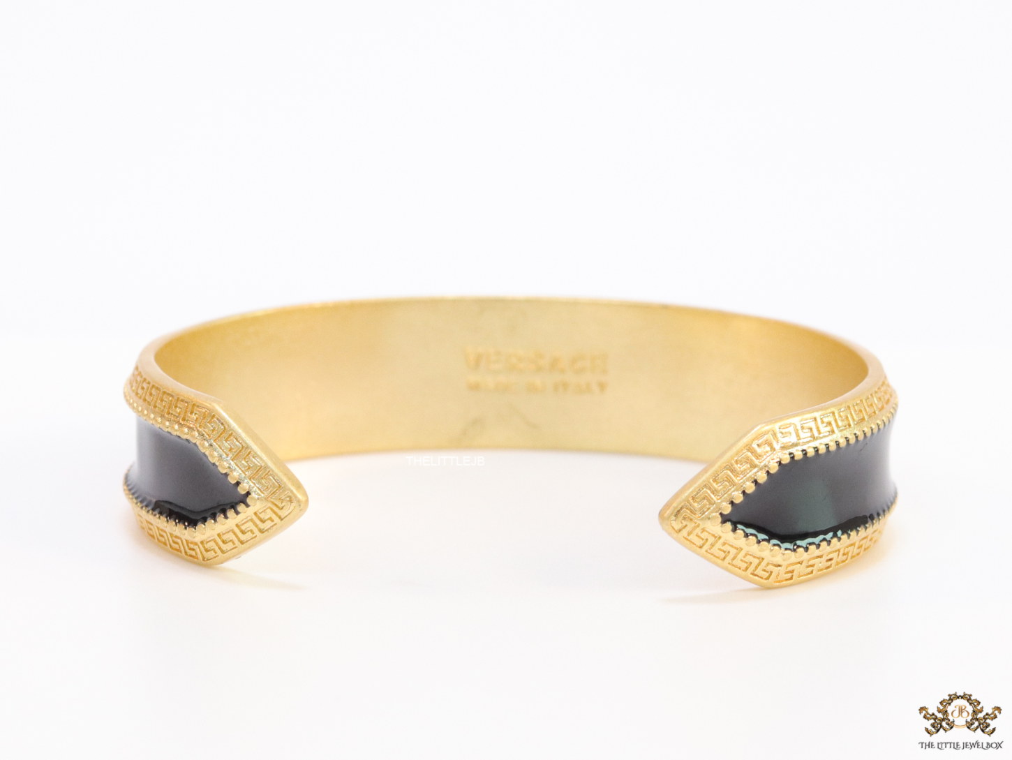 Band style black enamel bracelet with gold plated details and gold plated Medusa face motif