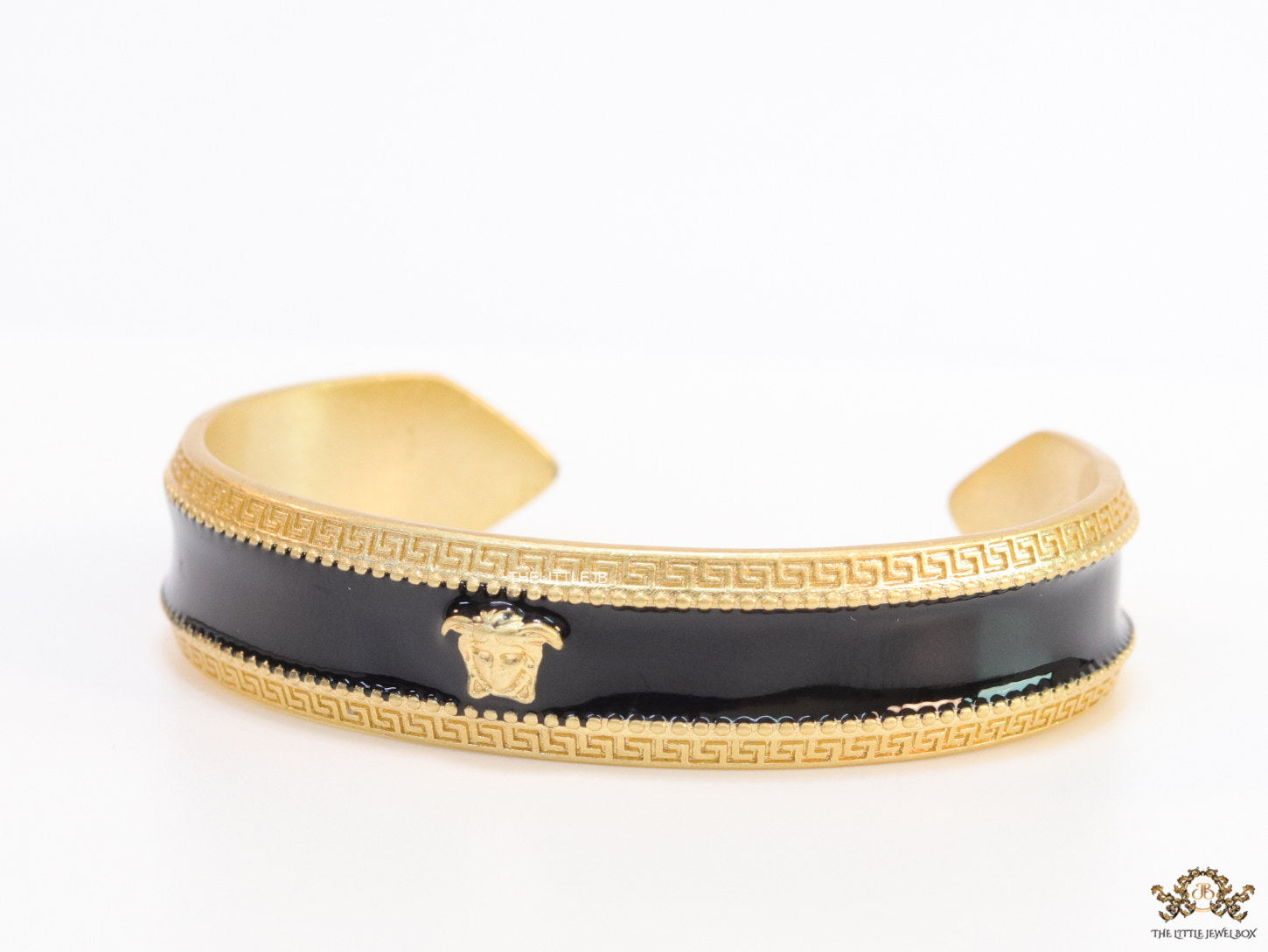 Band style black enamel bracelet with gold plated details and gold plated Medusa face motif