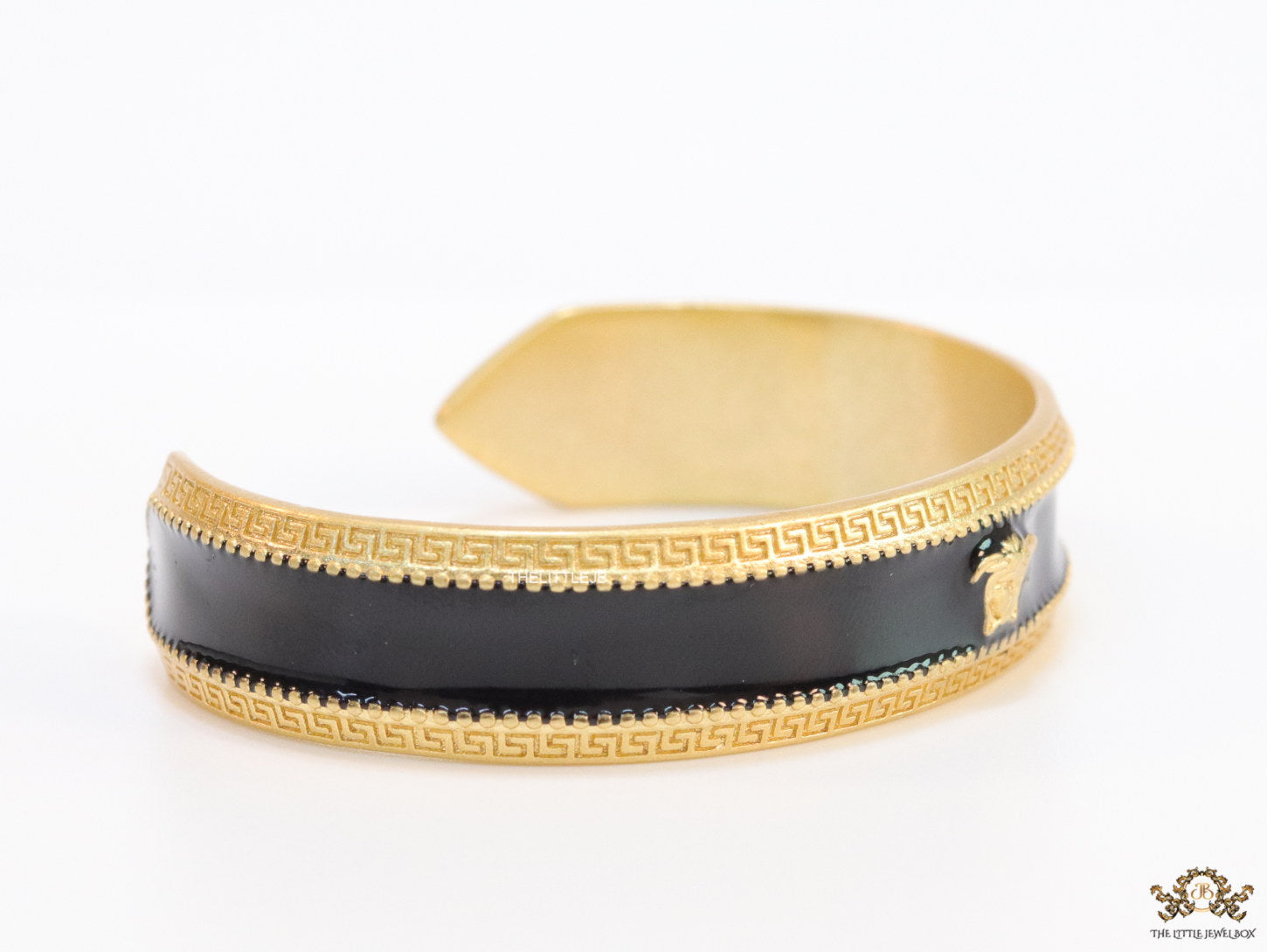 Band style black enamel bracelet with gold plated details and gold plated Medusa face motif