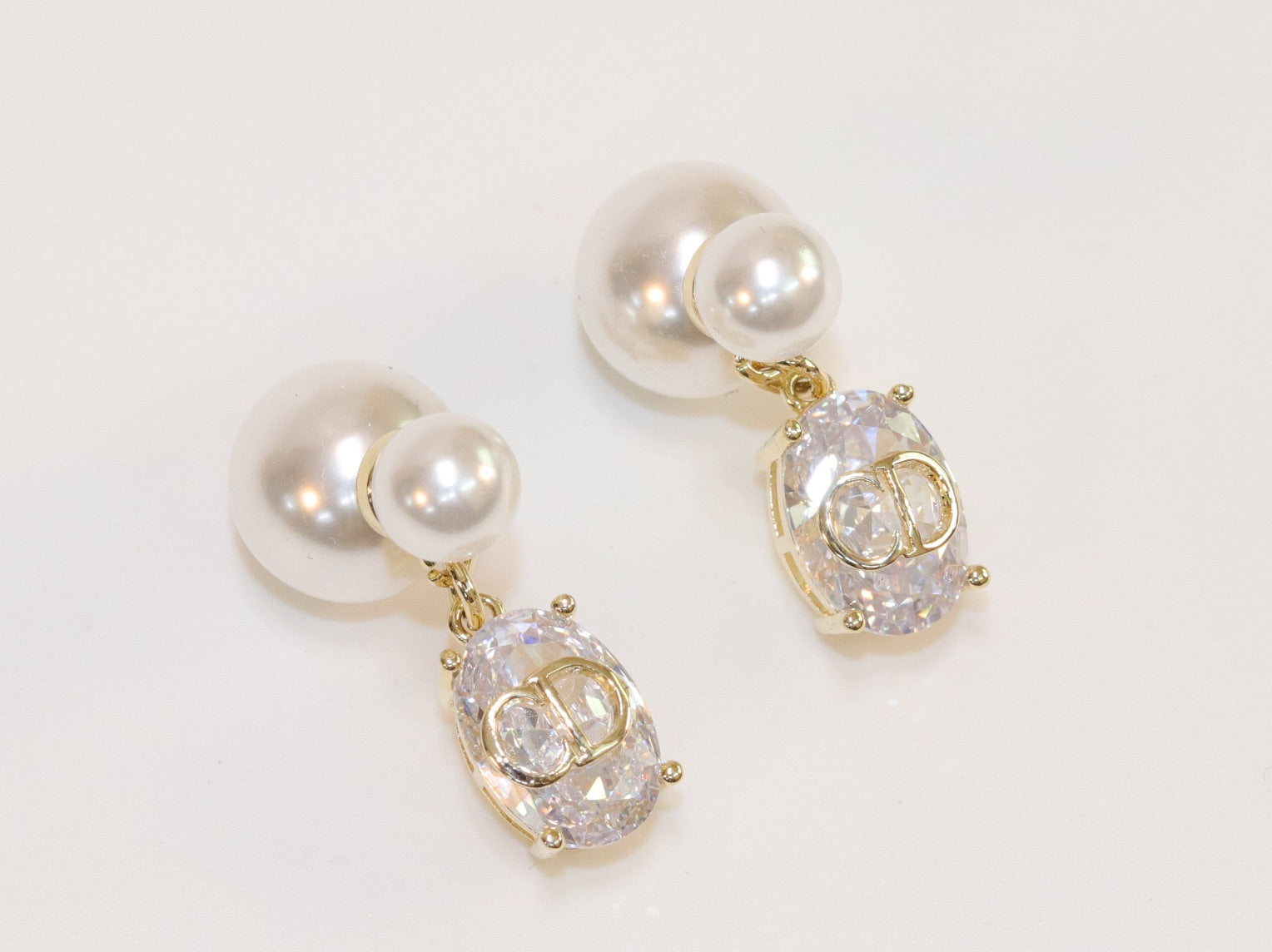 Alphabet C and D dangling stone pearl studs in platinum finish