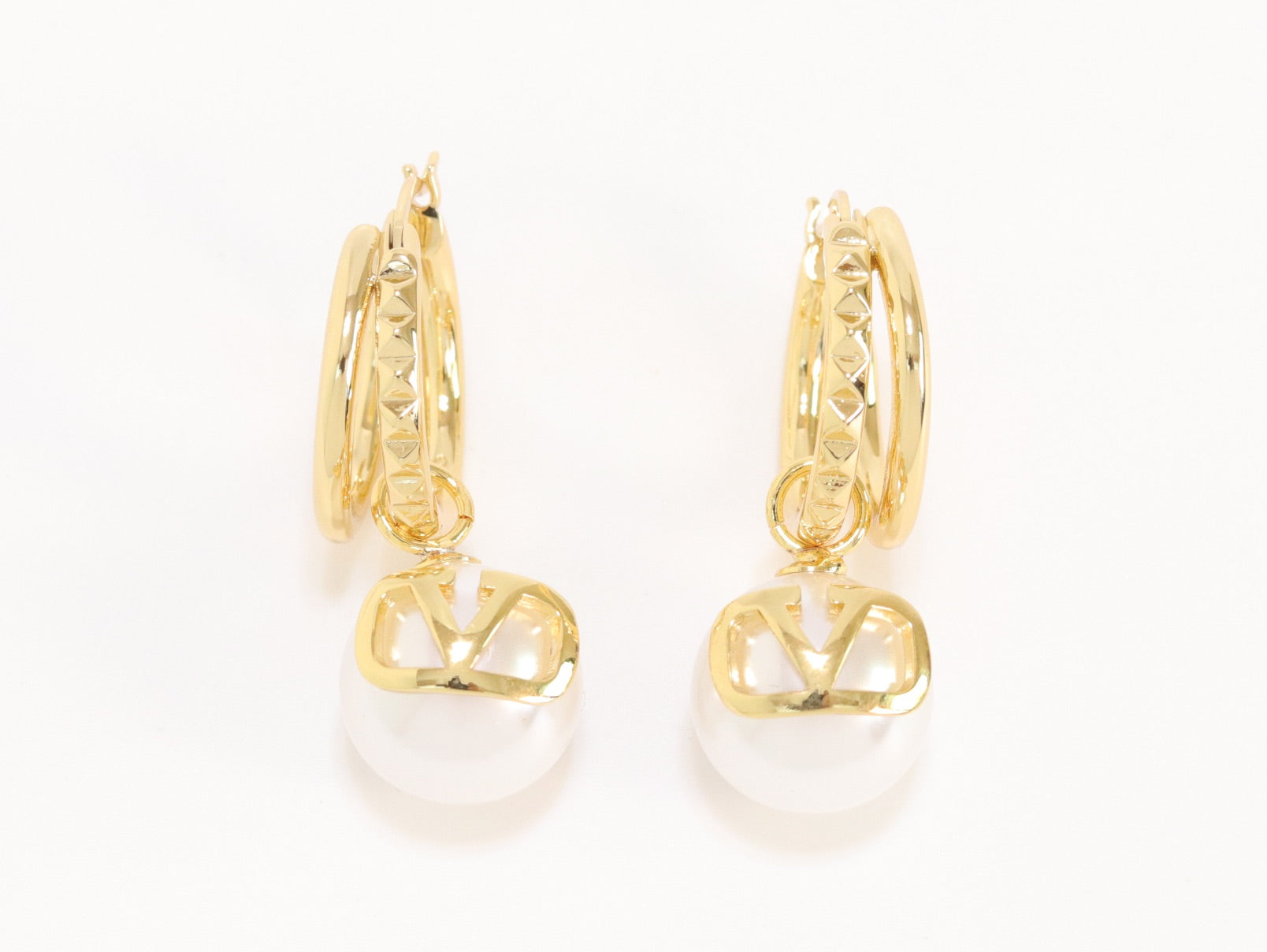 Alphabet V pearl dangling studs in gold finish