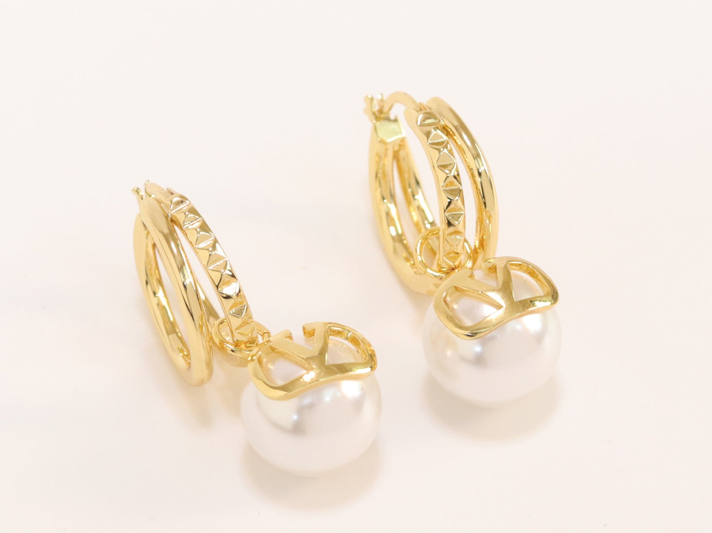 Alphabet V pearl dangling studs in gold finish