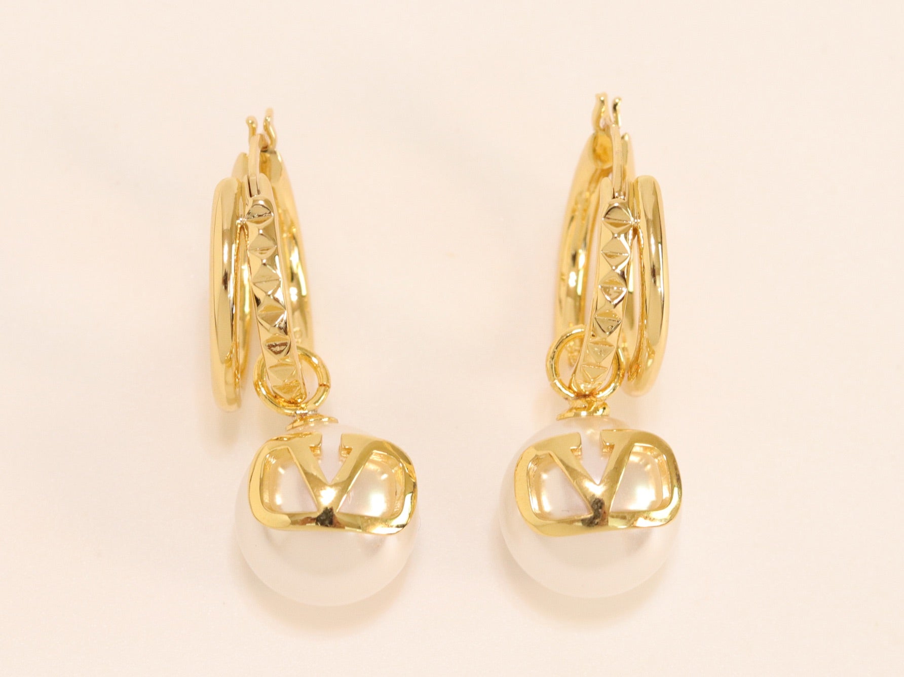Alphabet V pearl dangling studs in gold finish