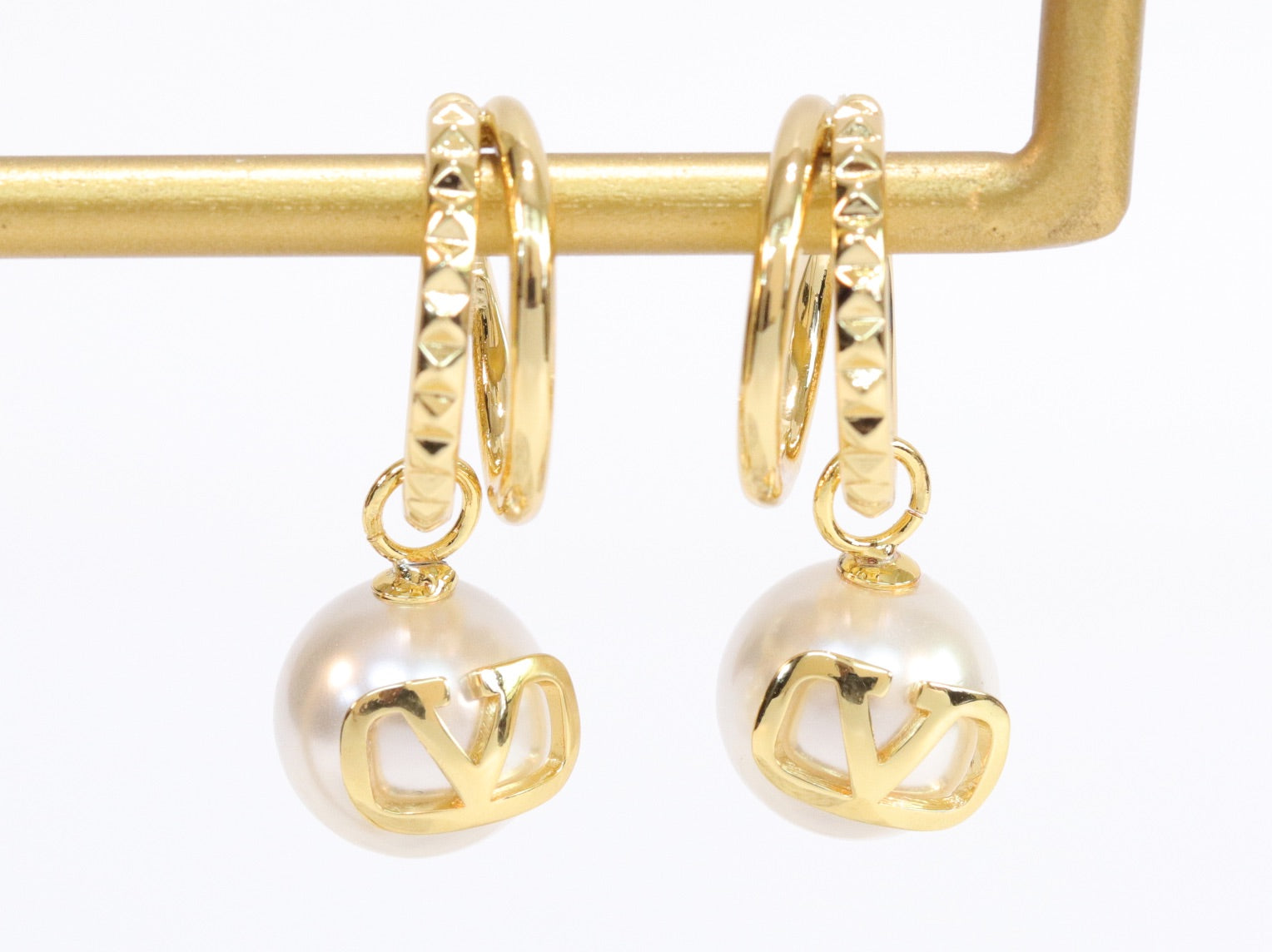 Alphabet V pearl dangling studs in gold finish