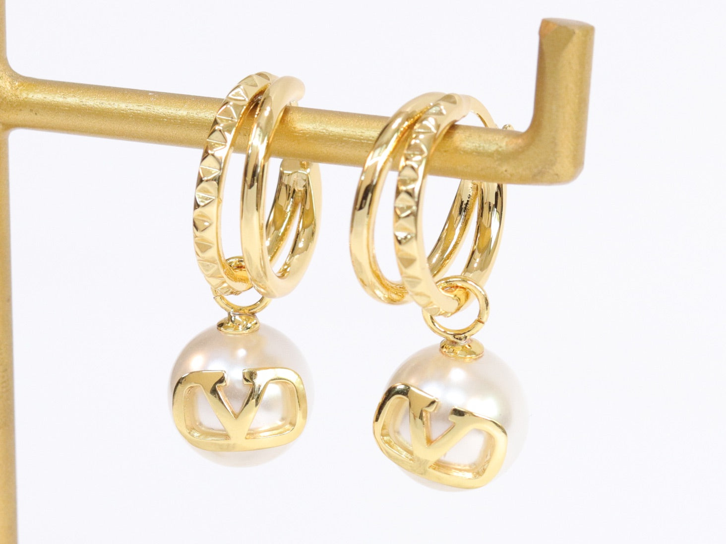 Alphabet V pearl dangling studs in gold finish
