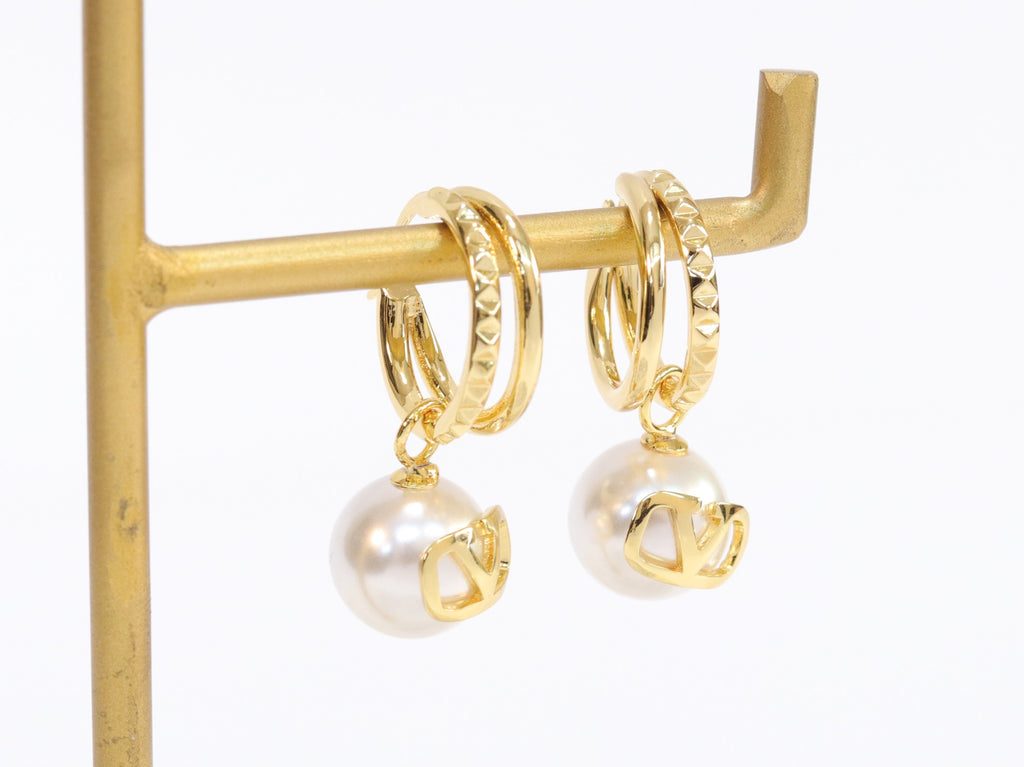 Alphabet V pearl dangling studs in gold finish