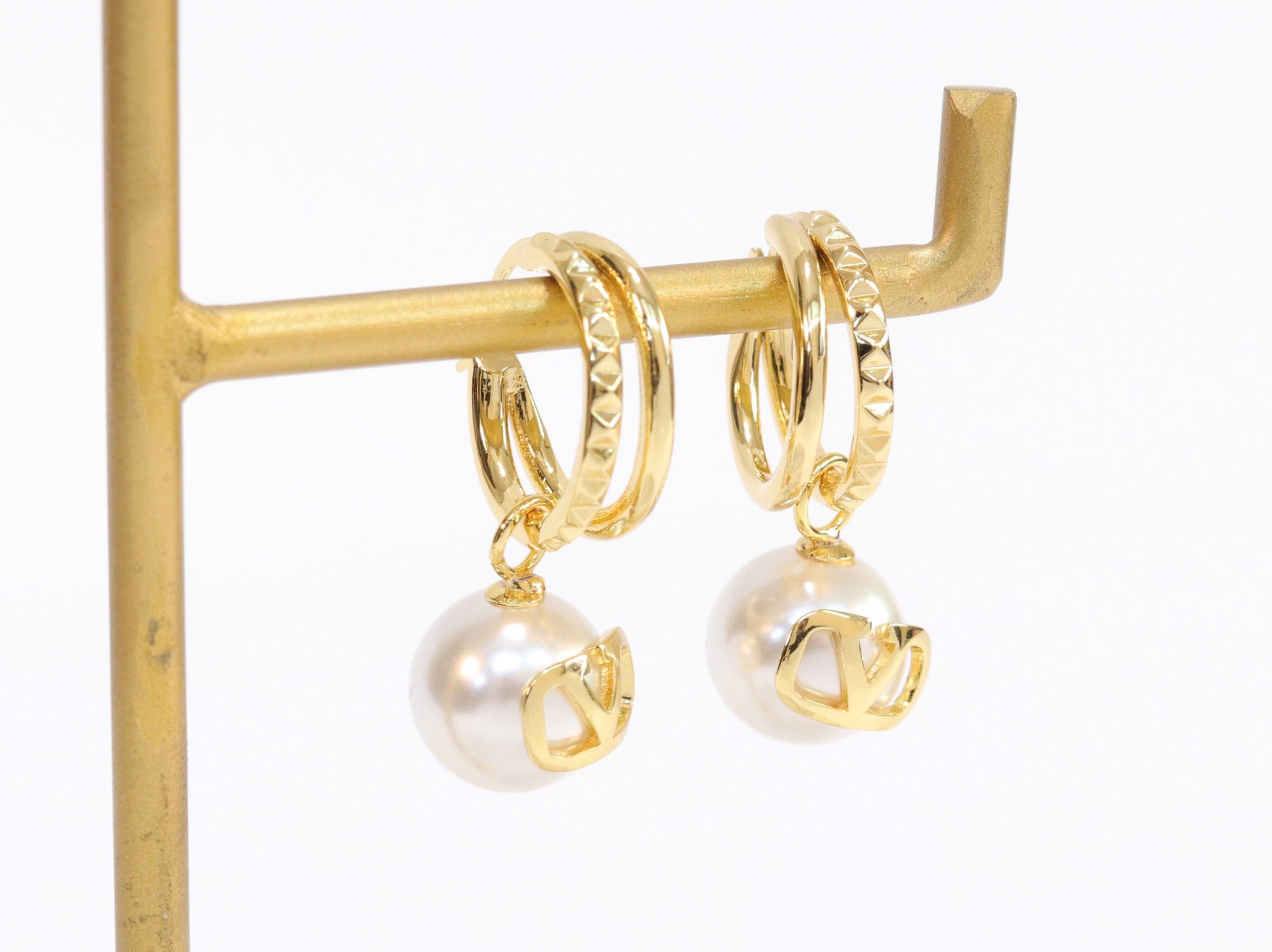 Alphabet V pearl dangling studs in gold finish
