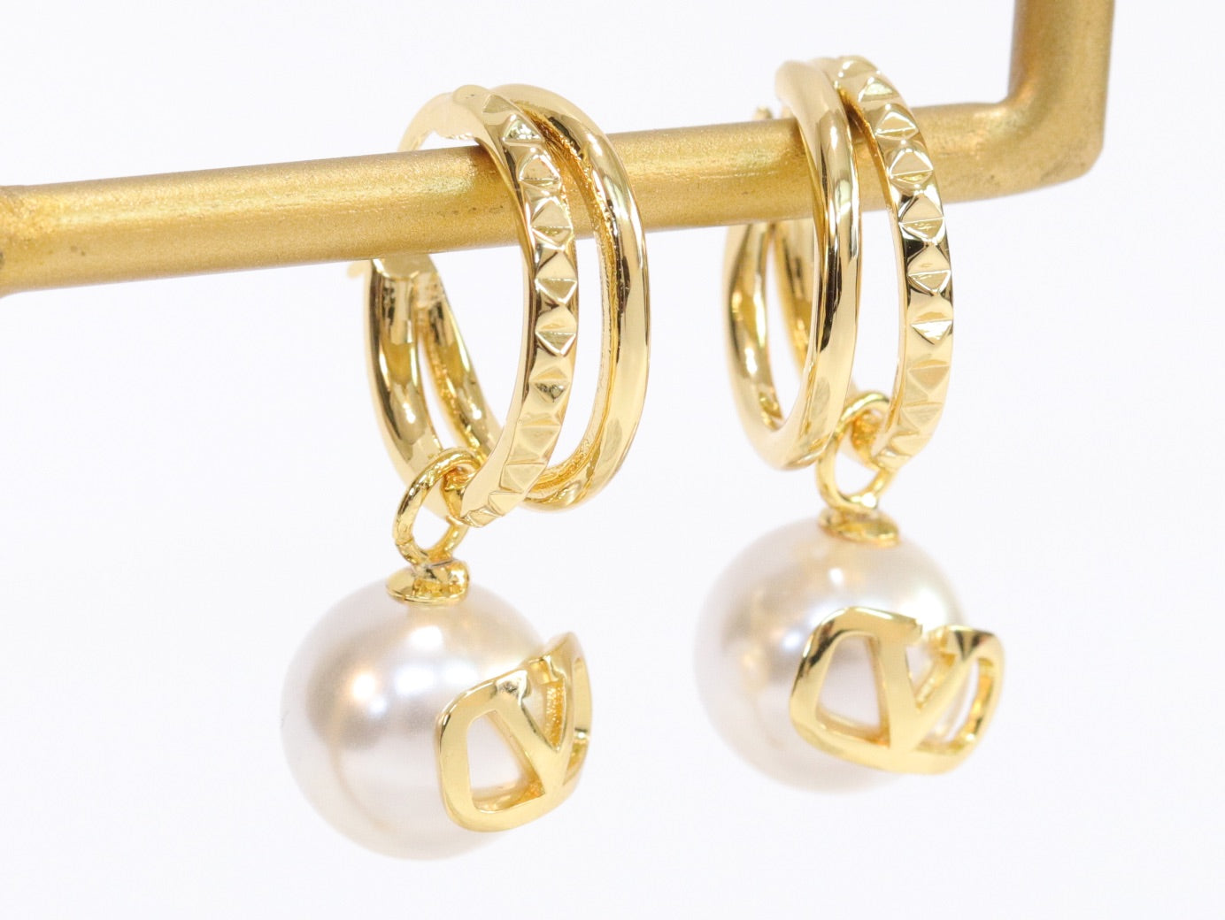 Alphabet V pearl dangling studs in gold finish