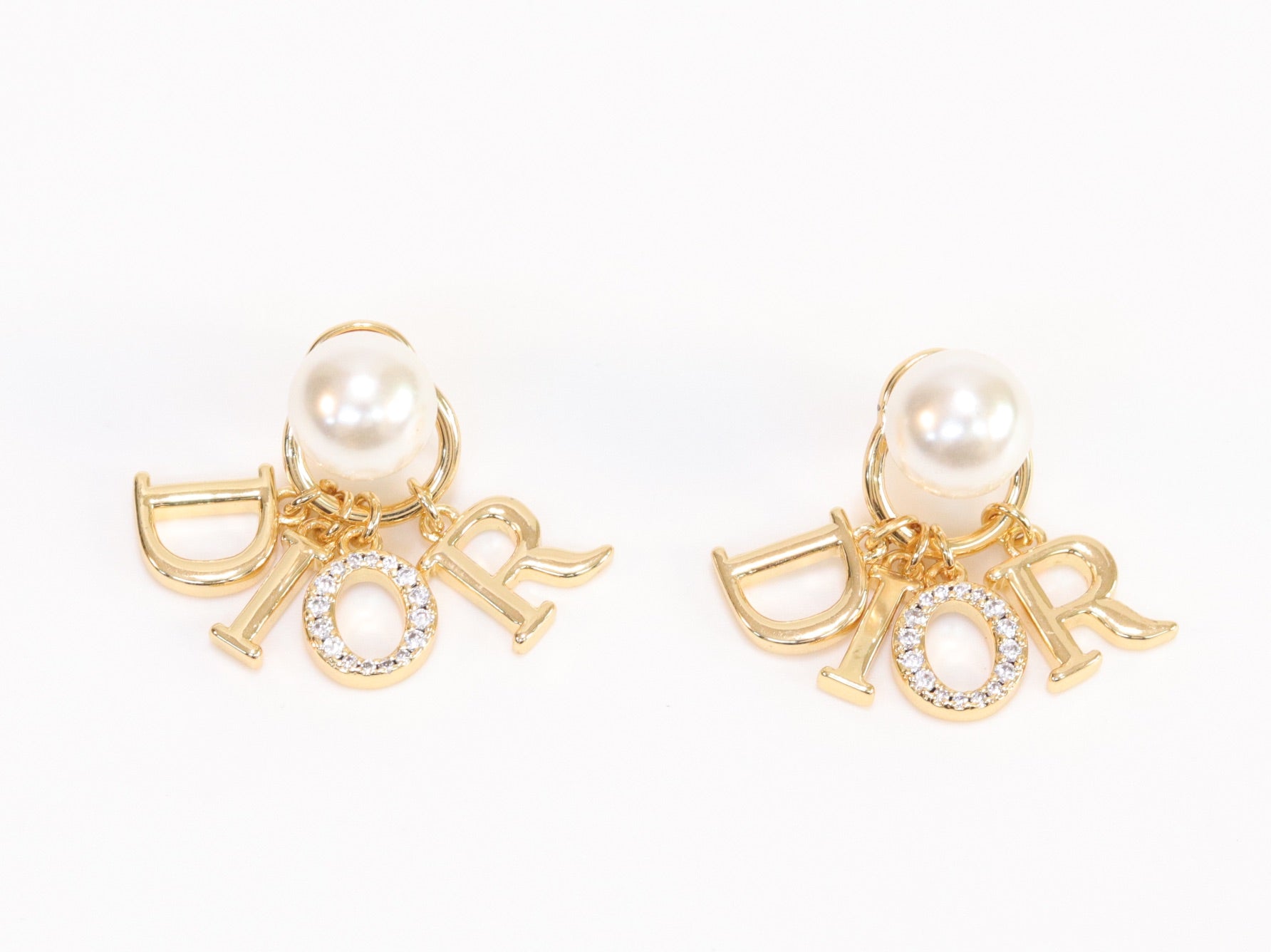 Alphabet CD dangling pearl studs in gold finish with CZ