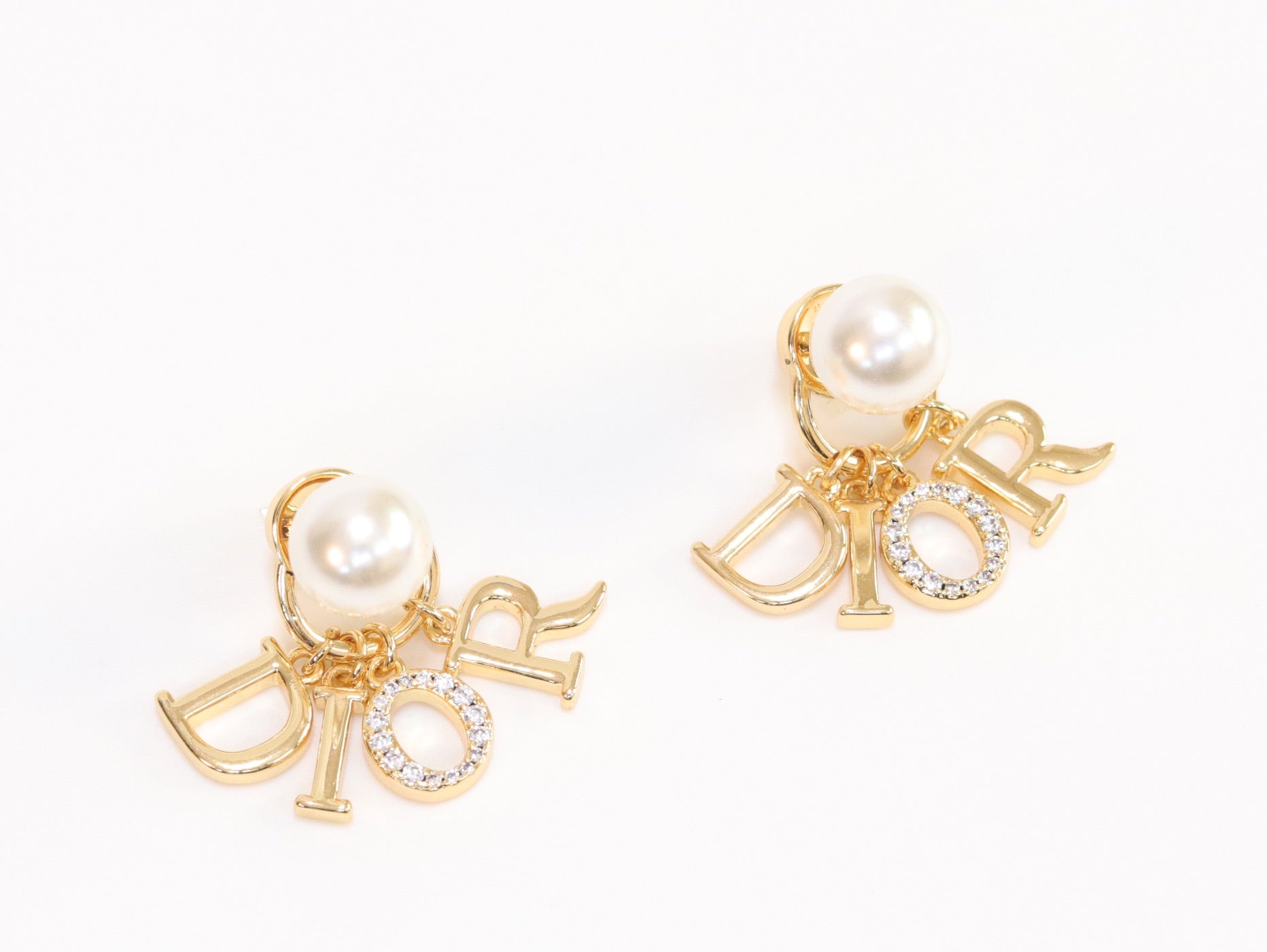 Alphabet CD dangling pearl studs in gold finish with CZ