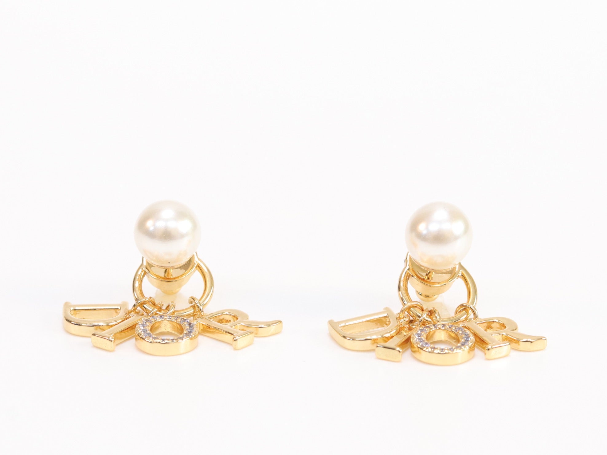 Alphabet CD dangling pearl studs in gold finish with CZ