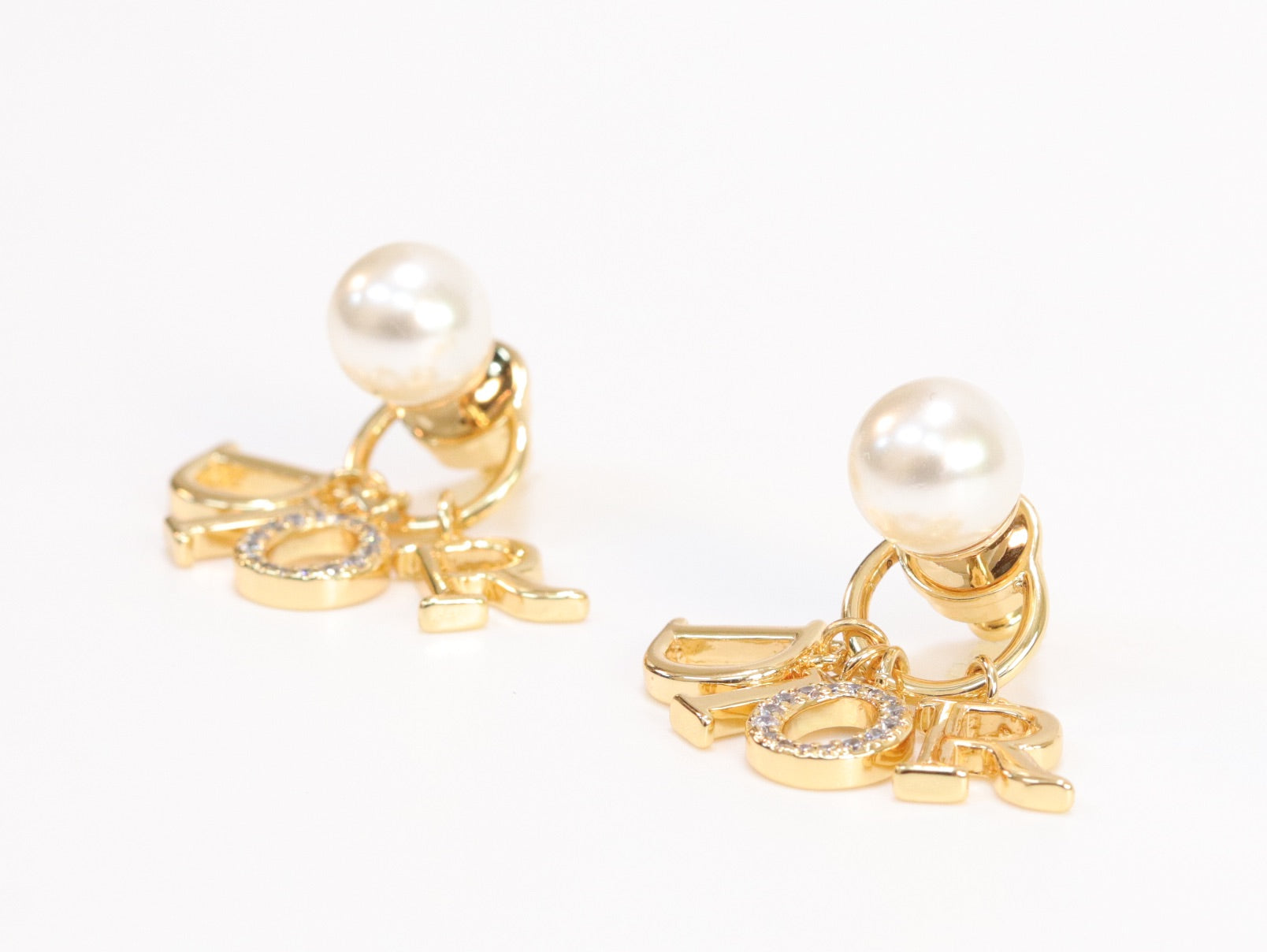 Alphabet CD dangling pearl studs in gold finish with CZ